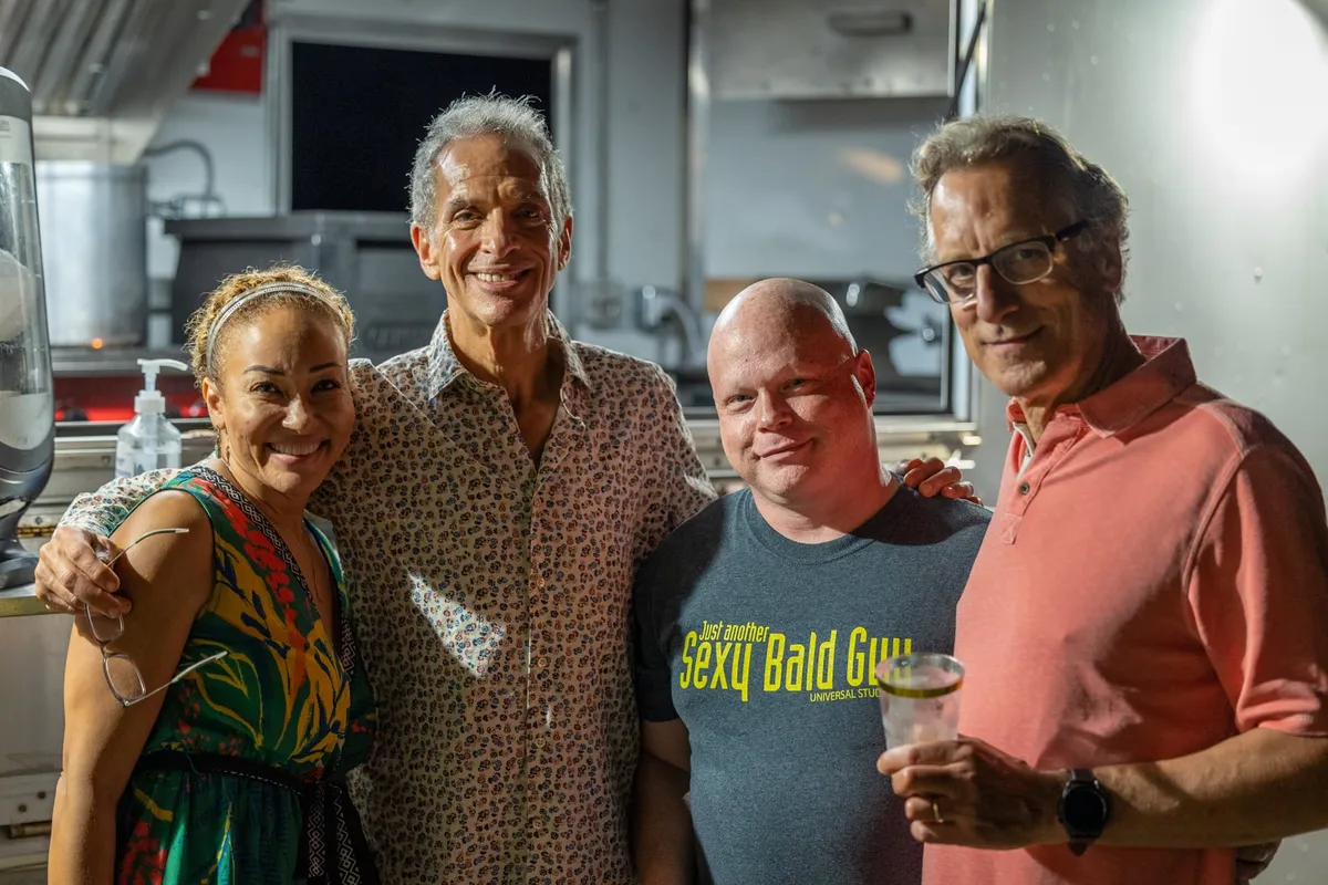 Four people posing together and smiling at an annual team Group Hug gathering