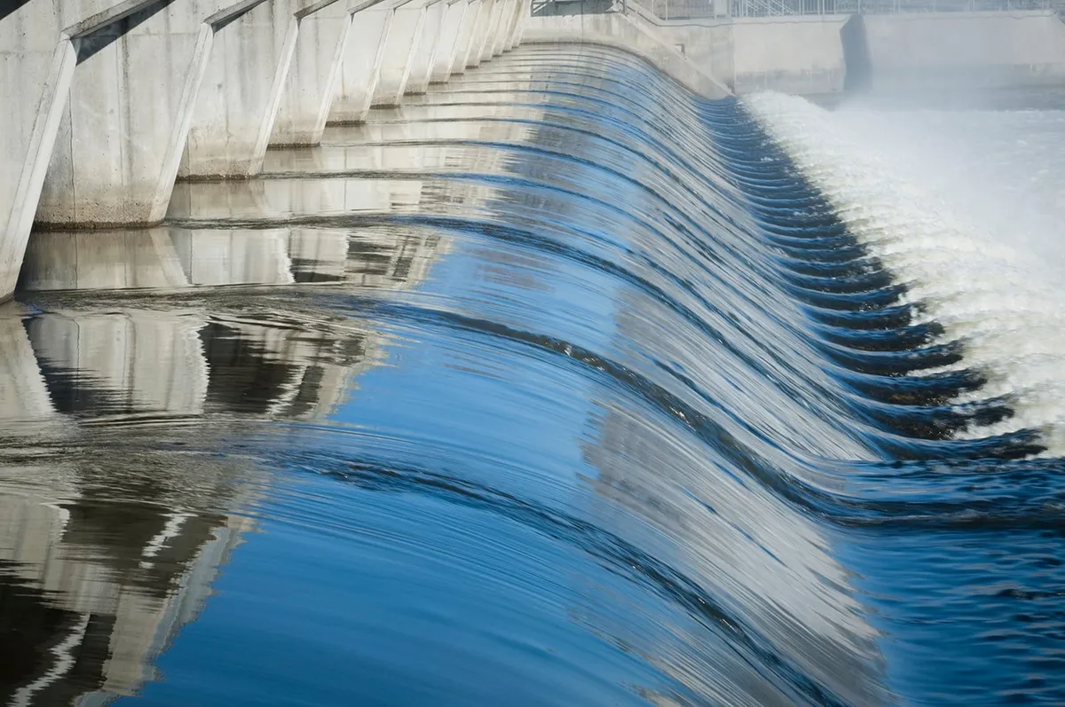 Water flowing over the curved spillway of a hydroelectric dam