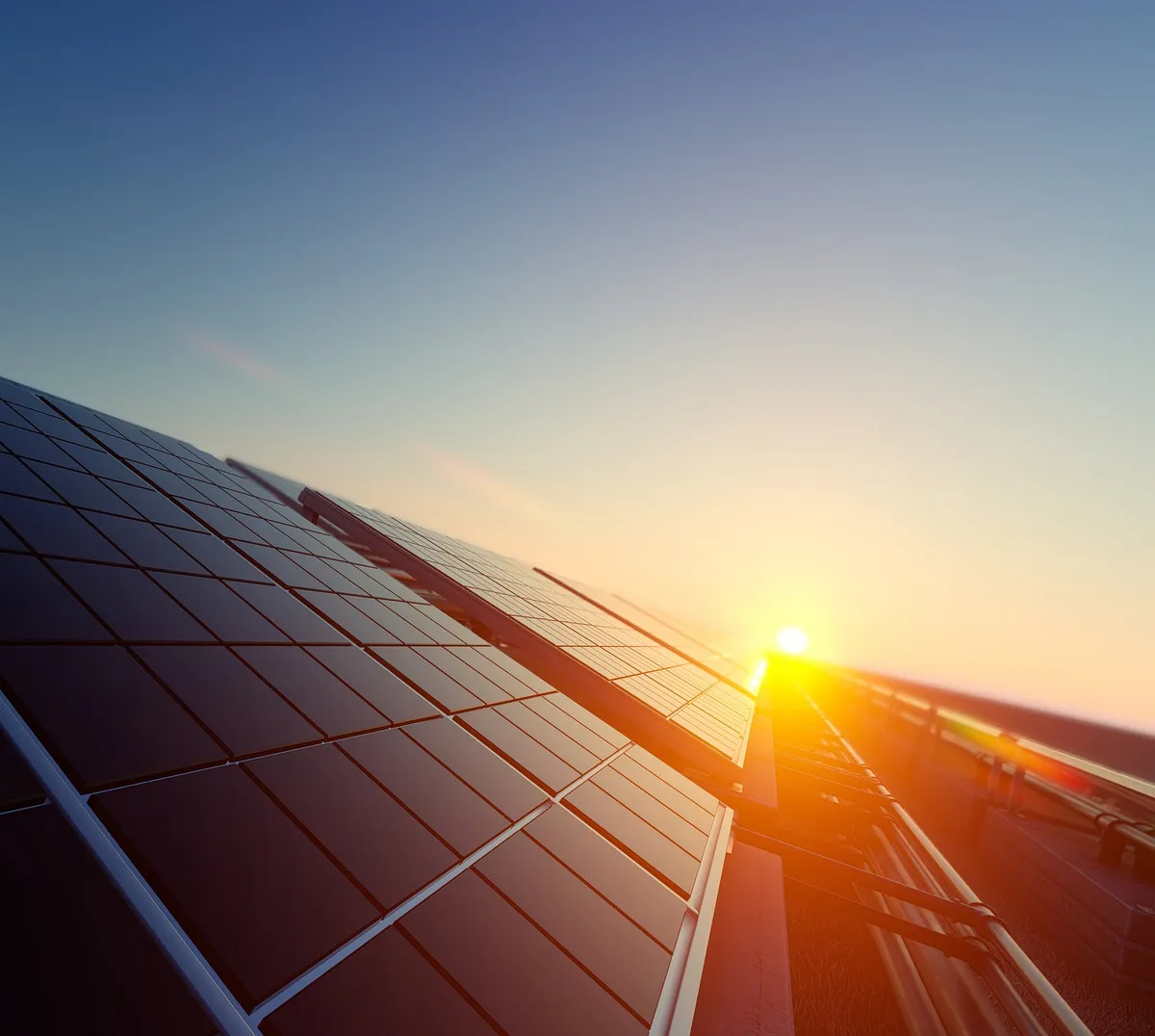 Solar panels in low sunlight with the sun on the horizon