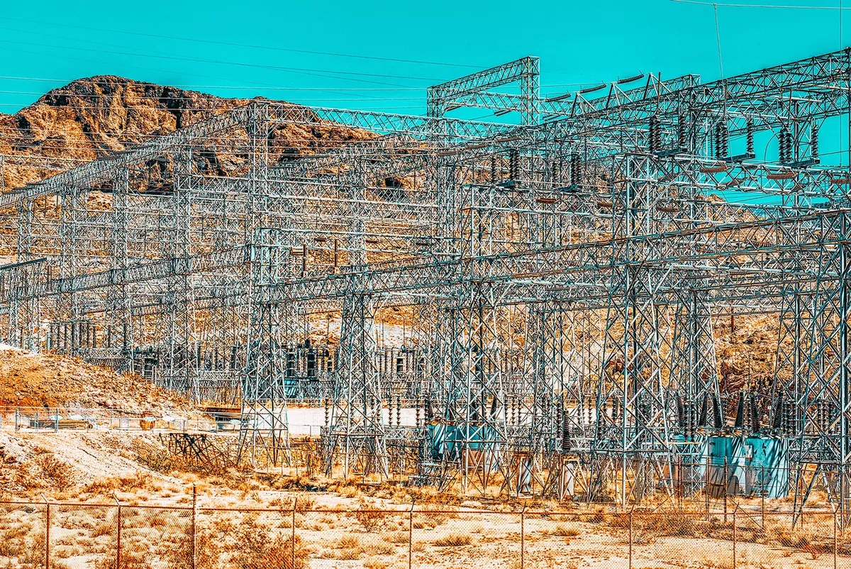 Steel lattice structures of an electrical substation in a rocky desert landscape